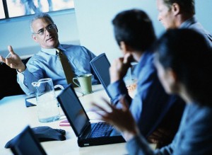 Businesspeople Using Laptops During Meeting