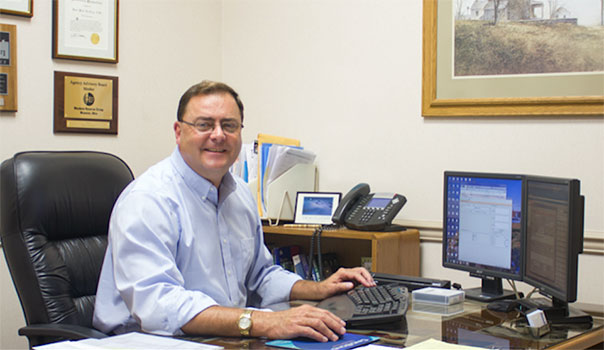 Perk Reichley smiling while working on his computer in the office